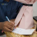 Hand holding a pen and write on a blank white paper, flower workshop