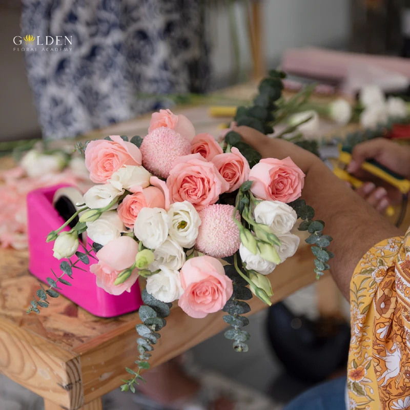 Hand is tying a bunch of fresh flowers