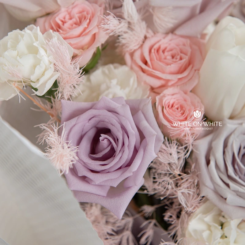 Close-up of pastel pink, purple, and white roses in a bouquet.