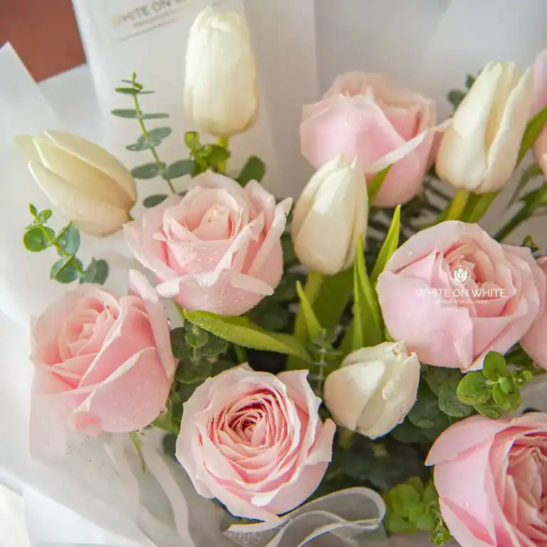 Pink roses and white tulips with greenery in a floral bouquet, fresh and elegant, perfect for special occasions.