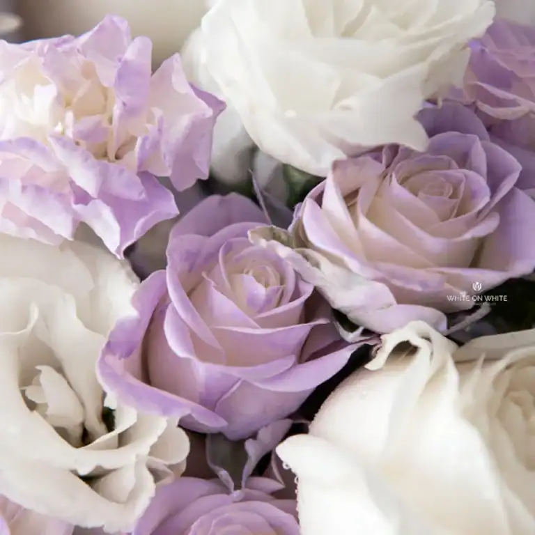 Lavender and white roses with hydrangeas in an elegant floral arrangement.
